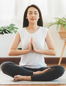 Woman meditating with hands in prayer position